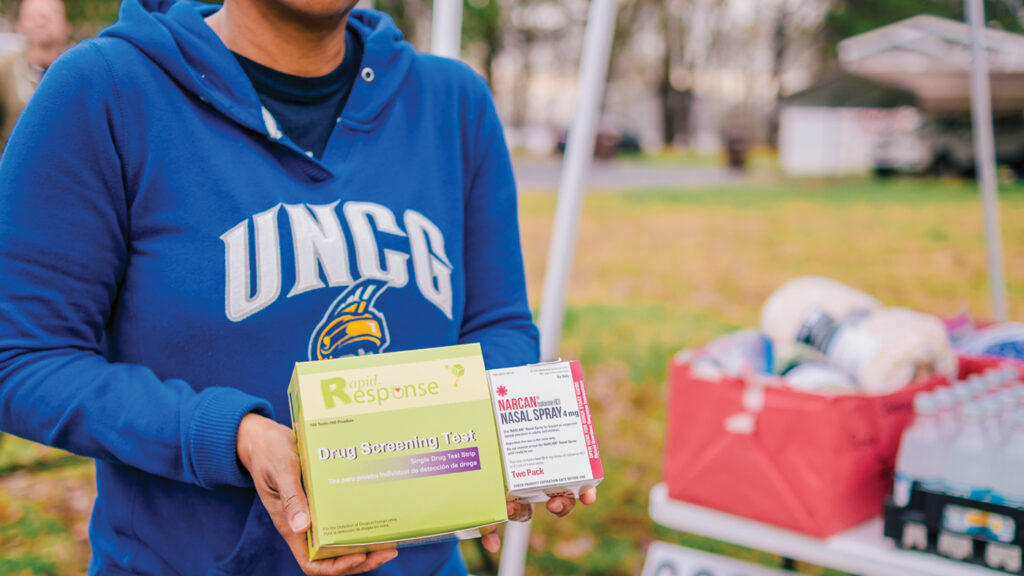 GCStop volunteer holding drug screening test and narcan